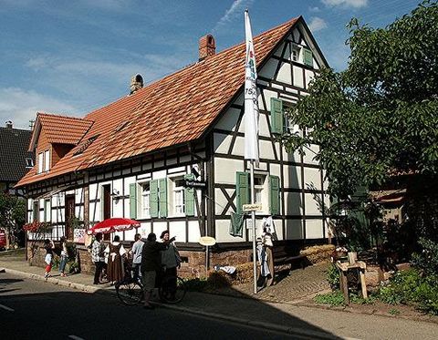 Das Bild zeigt das Fachwerkhaus. Es ist das Dorfmuseum "Kantebuahaus", sowie Menschen mit der Kleidung von früher (anlässlich 750-Jahr-Feier Marxzell in 2005).